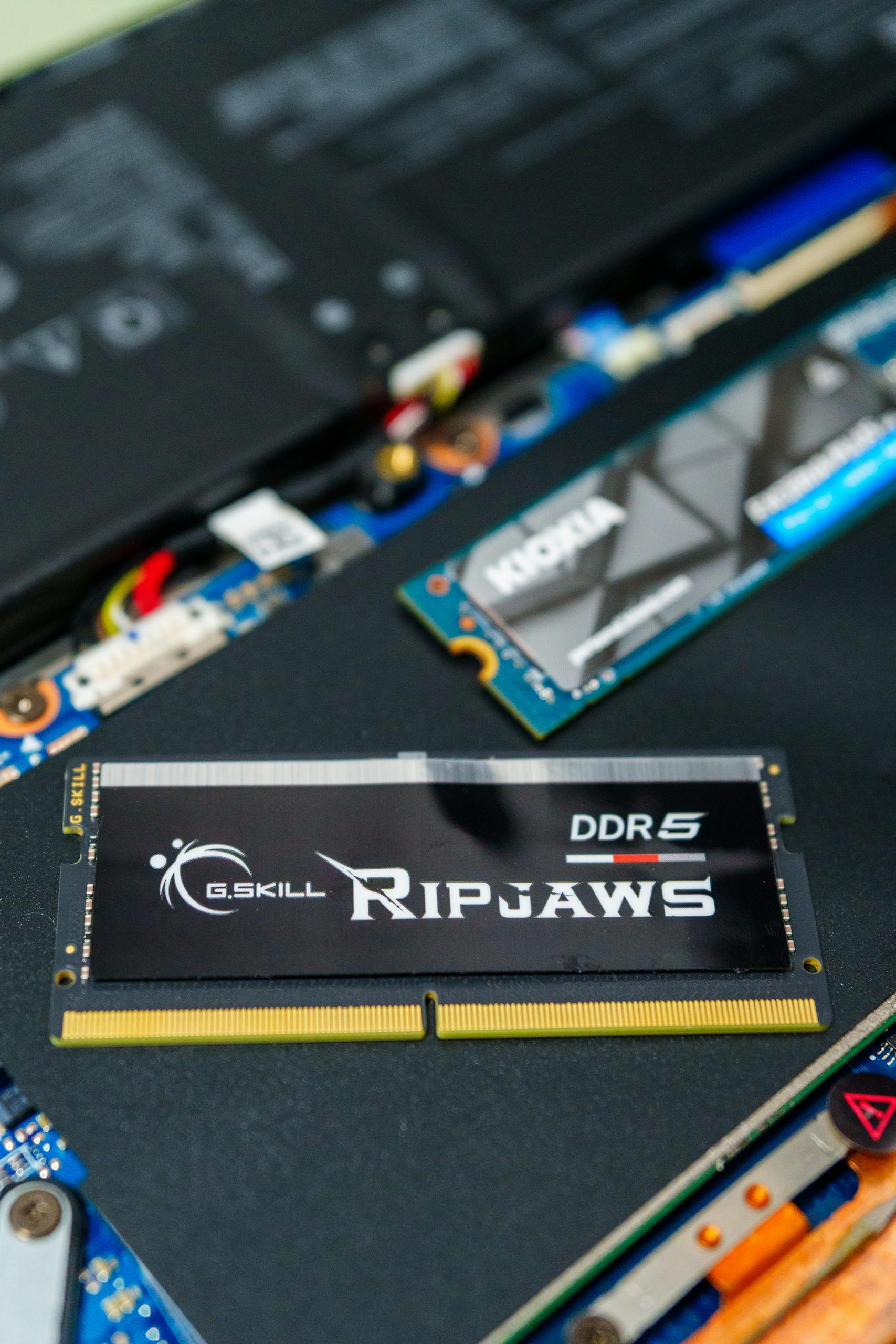 Detailed photo of a G.SKILL Ripjaws DDR5 RAM stick on a computer motherboard, showcasing modern technology.